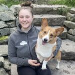 girl smiling with corgi in lap